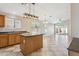 Open kitchen featuring a central island, tiled flooring, modern lighting, and plenty of room for entertaining at 11351 N 153Rd Dr, Surprise, AZ 85379