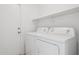 Functional laundry room with a white washer and dryer set, plus a shelf for storage at 11351 N 153Rd Dr, Surprise, AZ 85379