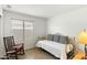 Cozy bedroom with tile flooring, a daybed, and a rocking chair by the window at 11925 N 67Th Dr, Peoria, AZ 85345