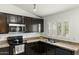 Kitchen with dark cabinets and granite countertops at 11925 N 67Th Dr, Peoria, AZ 85345