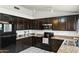 Kitchen featuring dark cabinets, granite countertops, and stainless steel appliances at 11925 N 67Th Dr, Peoria, AZ 85345