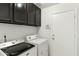 Functional laundry room with modern washer and dryer, ample cabinet storage, and a convenient access door at 11925 N 67Th Dr, Peoria, AZ 85345