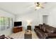 Bright living room features tile flooring, shutters, and a comfortable leather sofa at 11925 N 67Th Dr, Peoria, AZ 85345