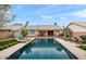 Backyard featuring a sparkling pool, lounge chairs, and lush landscaping at 11925 N 67Th Dr, Peoria, AZ 85345