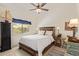 Cozy bedroom with wooden headboard, white bedding, and a view to the outdoors through a sunny window at 12749 E Poinsettia Dr, Scottsdale, AZ 85259