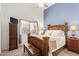 Comfortable bedroom with a light blue accent wall, wood furniture, and a window with blinds at 12749 E Poinsettia Dr, Scottsdale, AZ 85259