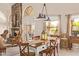 Bright dining room with stone fireplace, wood table, pendant lights, and views to the outdoor living space at 12749 E Poinsettia Dr, Scottsdale, AZ 85259