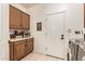 Functional laundry room with upper and lower cabinets, tile flooring, and access to the garage at 12749 E Poinsettia Dr, Scottsdale, AZ 85259
