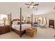 Bright main bedroom features a four-poster bed, neutral carpet, and comfortable seating area at 12749 E Poinsettia Dr, Scottsdale, AZ 85259