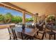Covered patio with a dining table, chairs, and view of a swimming pool and lush landscaping at 12749 E Poinsettia Dr, Scottsdale, AZ 85259
