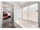 Bright bathroom with a soaking tub, large window, and view into the primary bedroom at 1425 E Darrel Rd, Phoenix, AZ 85042
