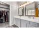 Bright bathroom featuring double sinks, quartz countertops, framed mirrors, and a closet at 1425 E Darrel Rd, Phoenix, AZ 85042