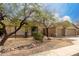 Inviting beige home with desert landscaping and a rock garden feature adds curb appeal to the property at 1425 E Darrel Rd, Phoenix, AZ 85042