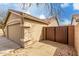 Beige home exterior featuring an attached garage with a tile roof, gate, and a well-kept desert landscape at 1425 E Darrel Rd, Phoenix, AZ 85042