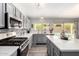 Modern kitchen featuring stainless steel appliances, gray cabinets, and quartz countertops at 1425 E Darrel Rd, Phoenix, AZ 85042