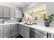 Charming kitchen with gray cabinets, quartz countertops, stainless steel appliances, and a view to outside at 1425 E Darrel Rd, Phoenix, AZ 85042