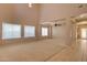 Spacious living room featuring carpeted flooring, large windows, and an elevated ceiling at 1524 N Milly Pl, Casa Grande, AZ 85122