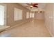 Open-concept living room with tile flooring, ceiling fan, and lots of natural light through the windows at 1524 N Milly Pl, Casa Grande, AZ 85122