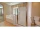 Primary bath showcasing a large soaking tub, separate glass shower, neutral tile, and commode at 1524 N Milly Pl, Casa Grande, AZ 85122