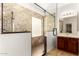Modern bathroom showcasing a glass shower with decorative stone-look tile walls at 15656 W Devonshire Ave, Goodyear, AZ 85395