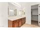 A spacious bathroom features double sinks, wood cabinets, and a large mirror at 15656 W Devonshire Ave, Goodyear, AZ 85395