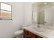 Bathroom with white sink, wood cabinets, and shower at 15656 W Devonshire Ave, Goodyear, AZ 85395