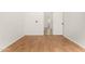 Clean bedroom featuring wood-look floors, white walls, and an open door at 15656 W Devonshire Ave, Goodyear, AZ 85395