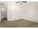 A spacious bedroom featuring neutral carpet, white walls, and a ceiling fan at 15656 W Devonshire Ave, Goodyear, AZ 85395