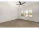 A bright bedroom with neutral carpet, a large window, and plantation shutters at 15656 W Devonshire Ave, Goodyear, AZ 85395