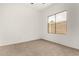 Bright bedroom with neutral carpet, white walls, and a window view of the backyard at 15656 W Devonshire Ave, Goodyear, AZ 85395