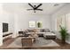 A modern living room featuring a comfortable sectional, ceiling fan, and natural light from the window at 15656 W Devonshire Ave, Goodyear, AZ 85395