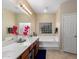 Bright bathroom featuring a double vanity, soaking tub with block glass window, and a separate toilet room at 16151 W Fairmount Ave, Goodyear, AZ 85395