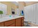Well-lit bathroom featuring a white vanity with a single sink and combined tub and shower at 16151 W Fairmount Ave, Goodyear, AZ 85395