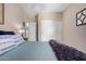 Calm bedroom features a plush bed, neutral walls, a ceiling fan, and a closet with sliding doors at 16151 W Fairmount Ave, Goodyear, AZ 85395