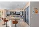 Open-concept kitchen boasts stylish cabinets, stainless appliances, island with bar seating and modern backsplash at 16151 W Fairmount Ave, Goodyear, AZ 85395