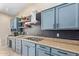 Charming kitchen features elegant blue cabinetry, modern appliances, and stylish backsplash for a modern touch at 16151 W Fairmount Ave, Goodyear, AZ 85395