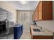 Functional laundry room featuring a blue washer and dryer, ample counter space, and storage cabinets at 16151 W Fairmount Ave, Goodyear, AZ 85395
