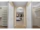 View from walk in closets through archway to main bedroom with ceiling fans and access to rear patio at 16151 W Fairmount Ave, Goodyear, AZ 85395