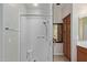 Glass enclosed shower features modern fixtures, bench and convenient grab bar; bathroom cabinet is visible at 16151 W Fairmount Ave, Goodyear, AZ 85395