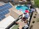 Backyard featuring pool, spa, solar panels, outdoor kitchen, patio, and beautifully landscaped yard at 16511 W Cortez St, Surprise, AZ 85388