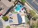 Aerial showcases home with solar panels, backyard pool, spa, desert landscaping, and outdoor living at 16511 W Cortez St, Surprise, AZ 85388