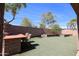 Spacious backyard features a patio, outdoor kitchen area and low-maintenance artificial turf at 16511 W Cortez St, Surprise, AZ 85388