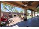 Inviting backyard features a covered patio, outdoor fireplace, grill, and well-manicured artificial lawn at 16511 W Cortez St, Surprise, AZ 85388