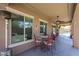 Covered patio with ceiling fan next to large picture windows and comfortable seating at 16511 W Cortez St, Surprise, AZ 85388