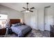 Bedroom features a wood bed frame, ceiling fan, ensuite, and wood-look flooring at 16511 W Cortez St, Surprise, AZ 85388