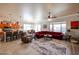 Spacious living room featuring a red sectional sofa and open kitchen with bar seating at 16511 W Cortez St, Surprise, AZ 85388
