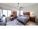 Spacious main bedroom with wood furniture, ceiling fan, and natural light from large windows at 16511 W Cortez St, Surprise, AZ 85388