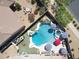 Aerial view of a backyard oasis with a sparkling pool, spa, slide, and mature landscaping, perfect for entertaining at 16511 W Cortez St, Surprise, AZ 85388
