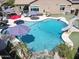 Aerial view of a sparkling private backyard pool with a slide, diving board, water feature, and patio at 16511 W Cortez St, Surprise, AZ 85388