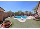Sparkling pool with a slide, diving board, and a rock waterfall, creating a fun backyard oasis at 16511 W Cortez St, Surprise, AZ 85388